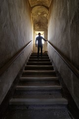 Fototapeta na wymiar Man silhouette on an old abandoned staircase 