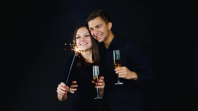 Young couple with glasses of champagne and a sparkler