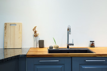Modern sink with wooden cutting board in kitchen room