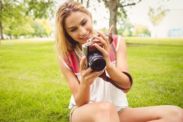 Smiling woman looking at camera while sitting on grass 