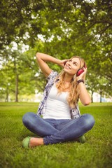 Obraz premium Full length of happy woman enjoying music at park
