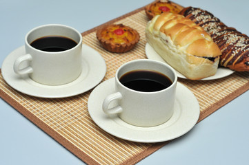 hot coffee with coconut tart and red bean bread on bamboo mat