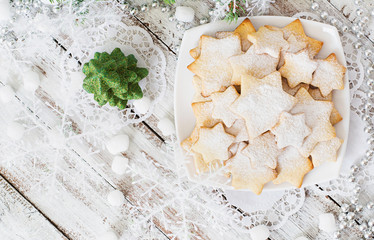 Christmas cookies and tinsel on a light wooden background