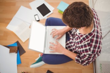 Naklejka premium Creative businessman working on laptop in office