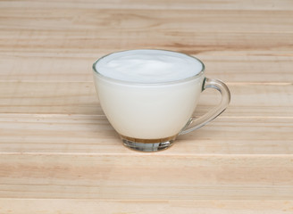 Hot milk on wood texture background