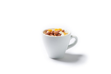 Pills capsules of medicament in coffee cup isolated on white bac