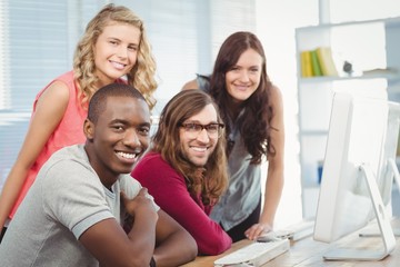 Portrait of smiling business team working at computer desk 