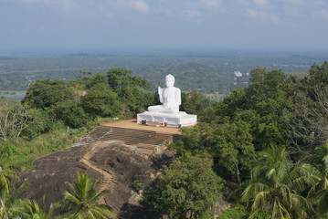 Fototapeta na wymiar Вид на скульптуру сидящего Будды на вершине горы. Михинтале, Шри-Ланка