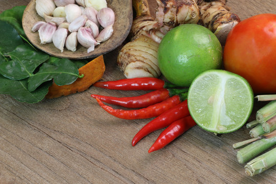 Thailand Food Ingredients: lemon, lime, galangal, ginger ,, tomato, mango leaves the dungeon, garlic on a wooden floor.