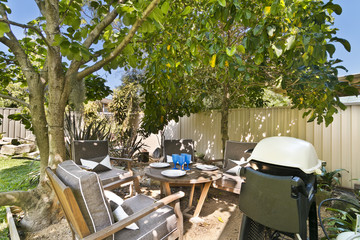 
cozy courtyard with furniture for outdoor recreation , with barbecue .