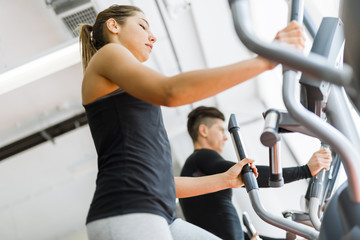 Fototapeta premium Beautiful fit young woman working out on a stepper