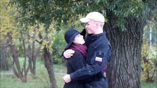 Осень. Первый снег. Парень обнимает девушку. Холодно, сильный ветер. Двое в парке. Эмоции, чувства, первая любовь 