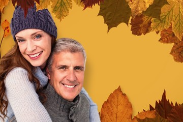 Composite image of happy couple in warm clothing