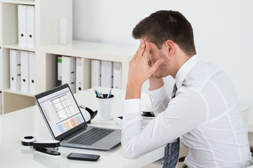 Fototapeta na wymiar Businessman Suffering From Headache At Desk