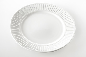 Empty white dinner plate with ridged rim