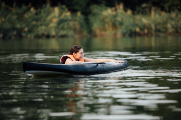 woman lying on a paddle board on water