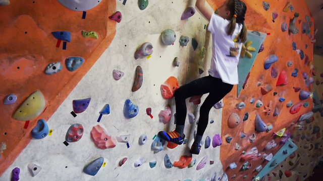 Child climbing on artificial boulders in gym