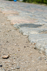 Old cobblestone road paved with urban stones