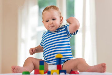 child boy playing with wooden toy blocks