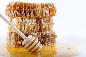 honeycomb with honey and honey stick on white background