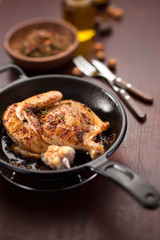 roasted half chicken on black pan