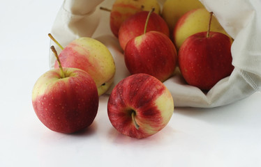 Red apples in a cloth bag on white background