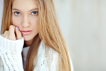 Fototapeta premium Young girl are posing in sweater at home