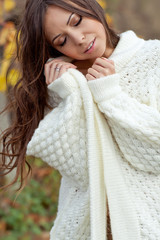 beautiful woman in a wool sweater are walking in autumn park 