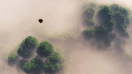 Naklejka premium Aerial of hot air balloon floating above misty forest.