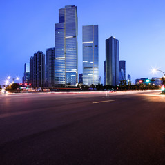 Fototapeta na wymiar asphalt road near skyscrapers at night