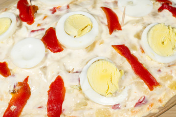 Detail of eggs an red peppers of a Russian salad (also known as Olivier salad)
