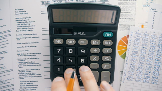 Businessman analyzing the market and considers on the calculator