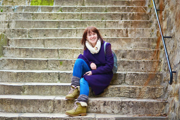Young tourist in Paris, sitting on the stairs on Montmartre