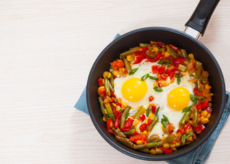 fried eggs with mixed vegetables in a frying pan