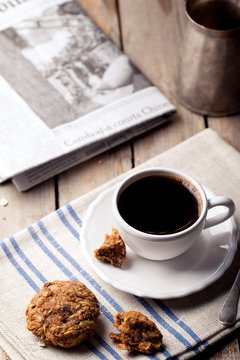 Cup of coffee with cookies and morning newspaper