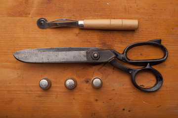 dressmaker shears craft concept with polw and thimble on wooden