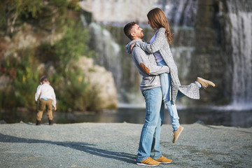 A young parents is hugging each other and his child