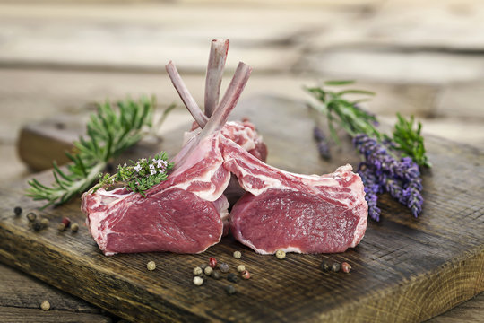 Rohes Lammfleisch als Lammkarree auf edlem Holzbrett