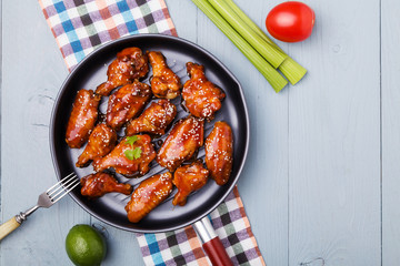 Baked chicken wings in honey sauce sprinkled with sesame seeds.