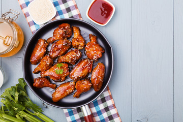 Baked chicken wings in honey sauce sprinkled with sesame seeds.