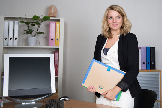 Blond young woman at office looking at the camera