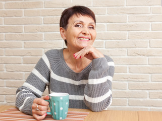 50 years old attractive woman with a cup of tea at home