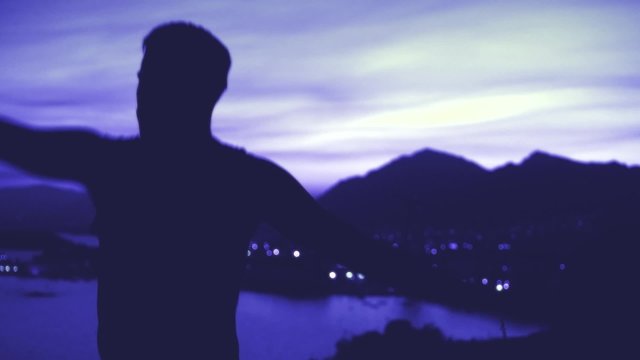 hombre bailando como un tonto en paisaje costero a contraluz