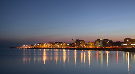 City on the bank of the ocean at night