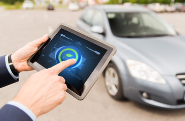 close up of male hands with tablet pc and car