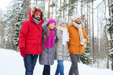 group of smiling men and women in winter forest