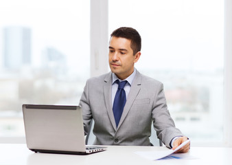businessman with laptop and papers