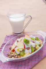 Healthy bowl of muesli, apple, fruit, nuts and milk for a nutrit