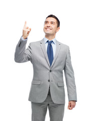 happy businessman in suit pointing finger up