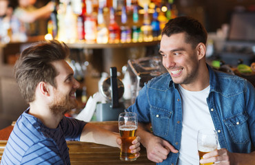 happy male friends drinking beer at bar or pub
